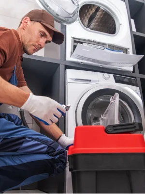 Technician repairing a clothes dryer showing internal maintenance and fixing issues