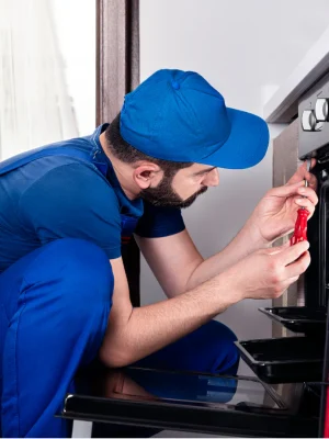 Technician repairing electric stove at customer home