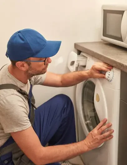 Technician repairing washing machine at home appliance service