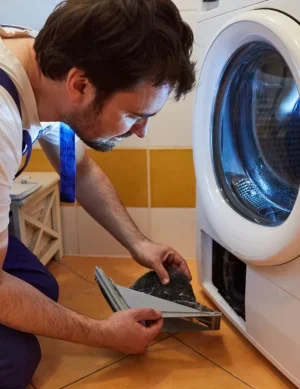 Technician checking washing machine for repair and maintenance issues