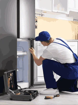 repair man repairing refrigerator at home kitchen appliance service