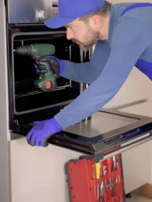 Technician installing a built-in oven in modern kitchen