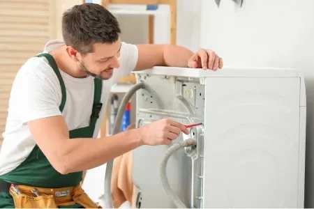 Technician repairing washing machine